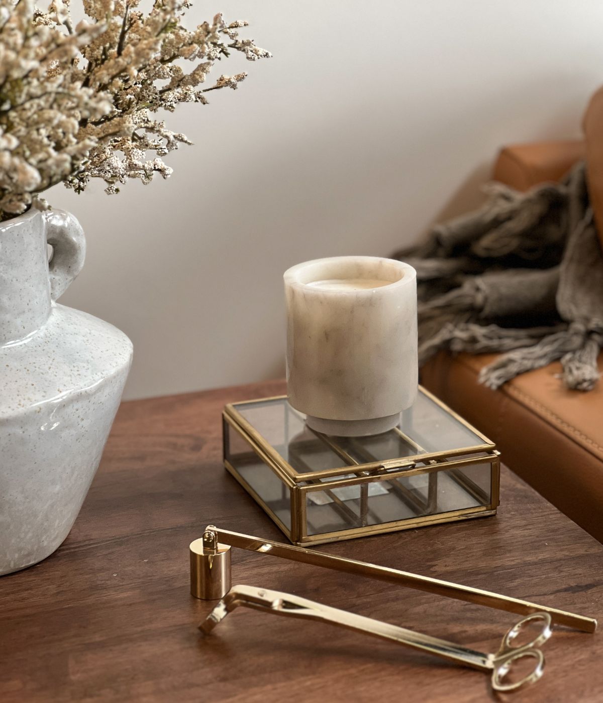 White marble candle with gold snuffer and trimmer.