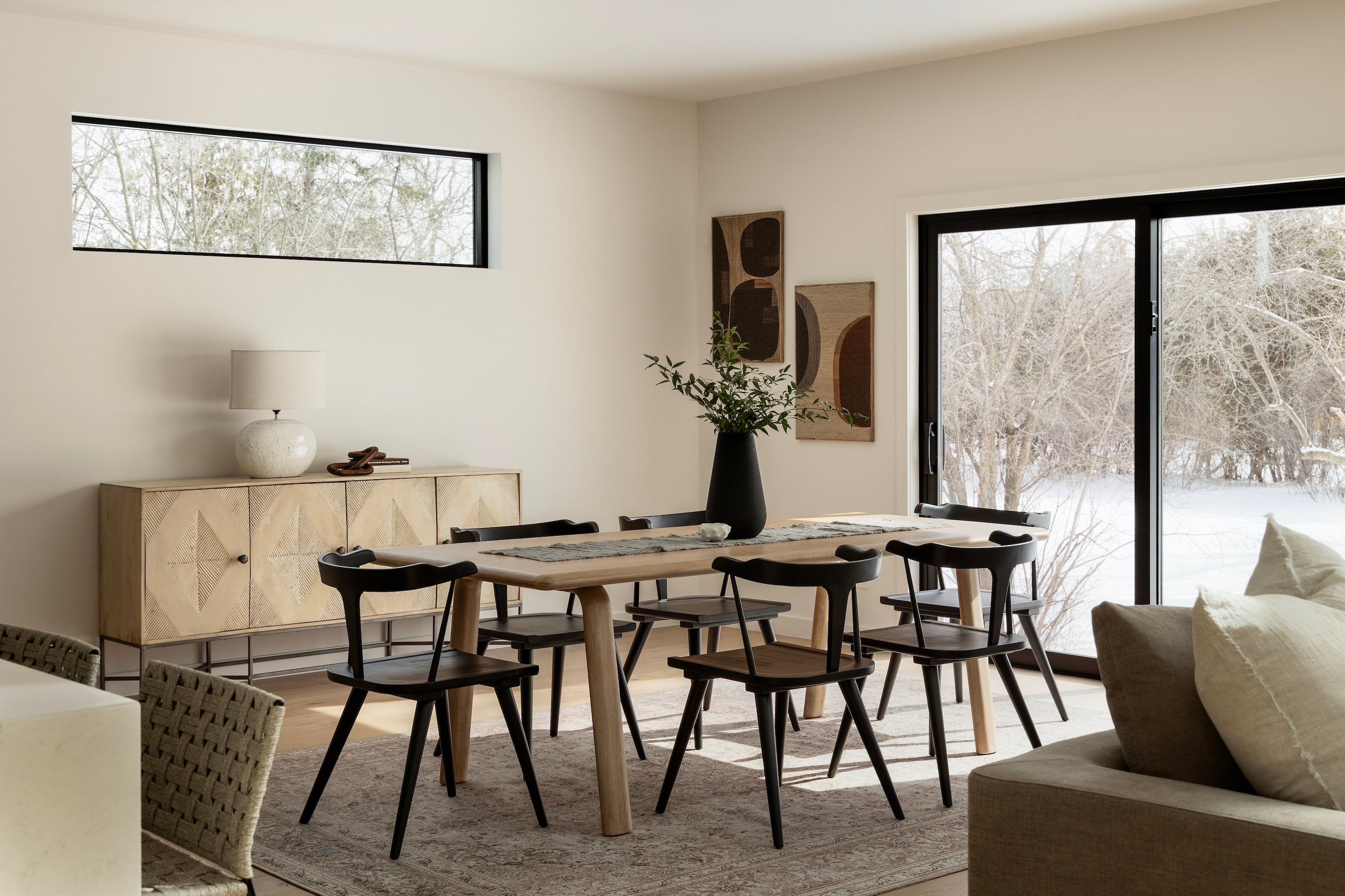 Contrasting dining room, light wood table and black dining chairs.